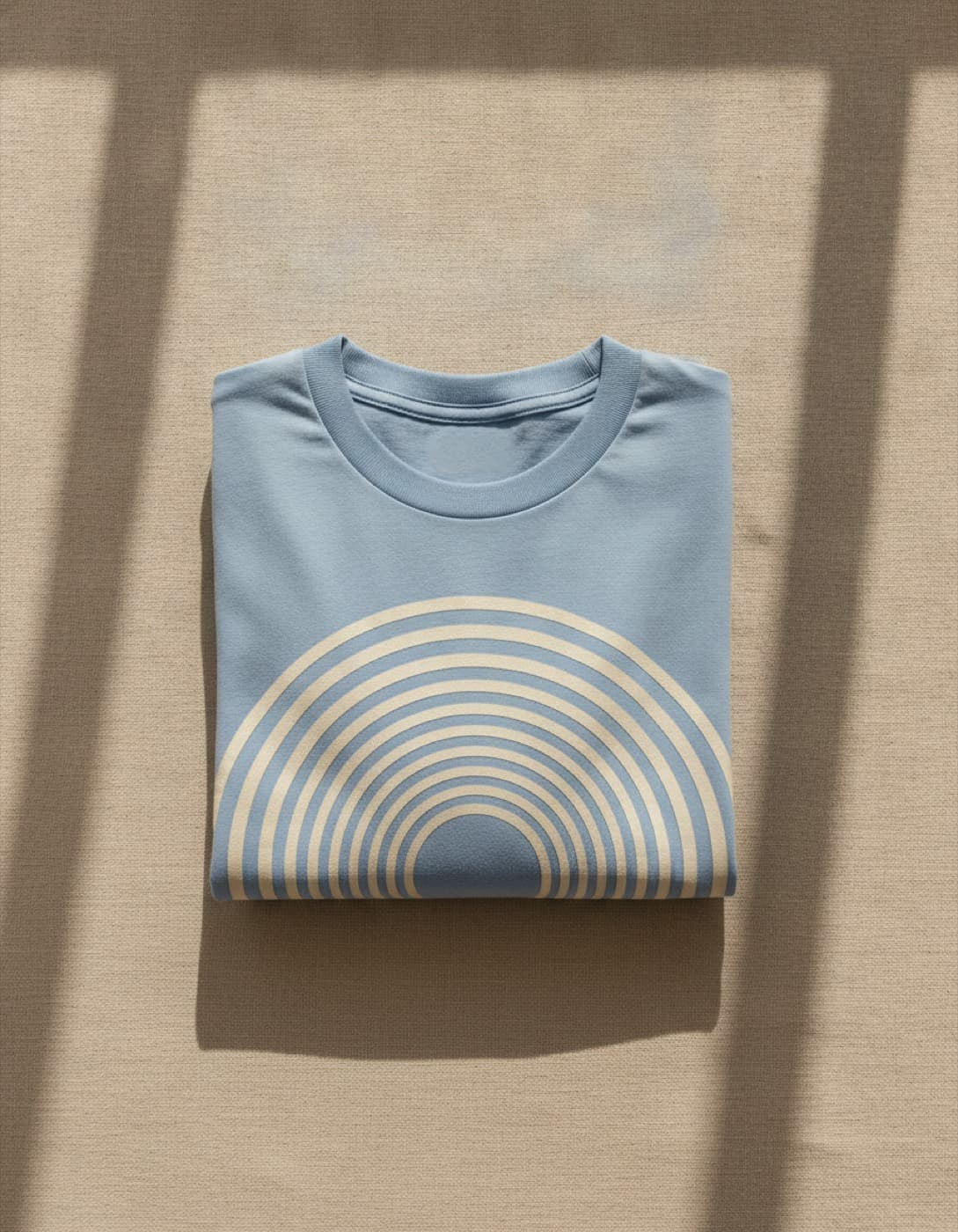 Camiseta oversize azul cielo doblada, con un estampado de arcos concéntricos